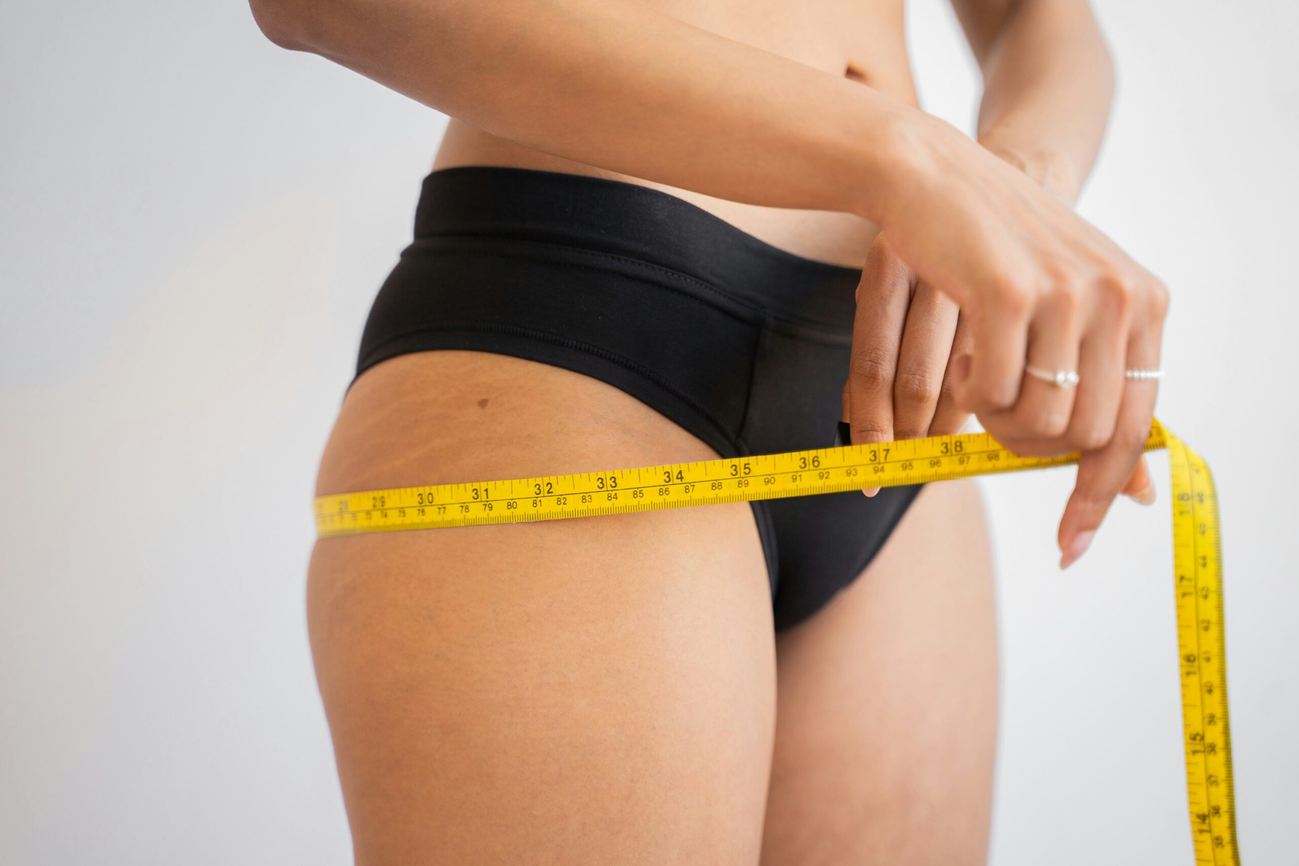 Lady measuring waist with metric tape